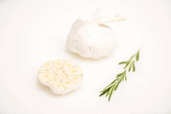 Garlic and rosemary twig isolated on white — Stock Photo