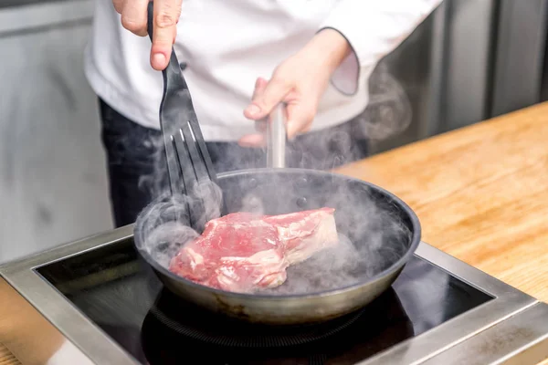 Image recadrée du chef en remuant la viande avec la spatule — Photo de stock