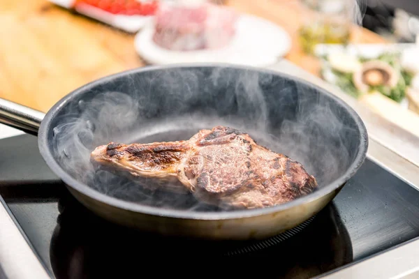 Frying appetizing meat in restaurant kitchen — Stock Photo