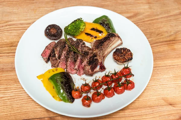 Overhead view of cooked meat with vegetables on plate — Stock Photo