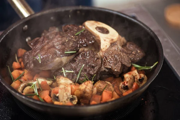 Appetizing vegetables stew and meat on frying pan — Stock Photo