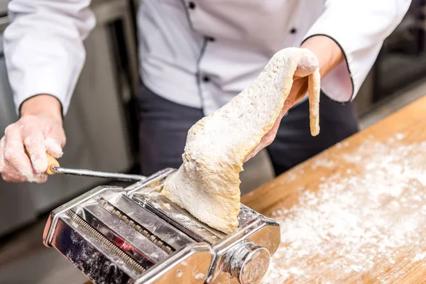 Immagine ritagliata dello chef che fa la pasta con la macchina della pasta — Foto stock