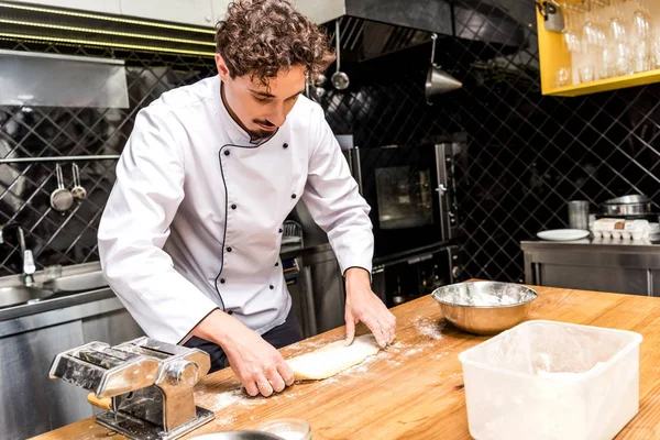 Chef preparing dough for pasta on table — Stock Photo
