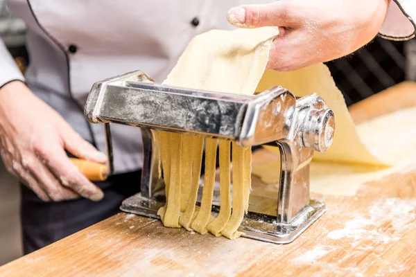 Обрезанный образ шеф-повара, делающего макароны с макаронами — стоковое фото