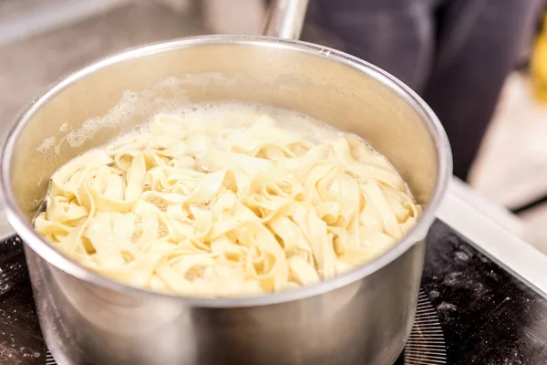 Preparación de deliciosa pasta en la cocina del restaurante - foto de stock