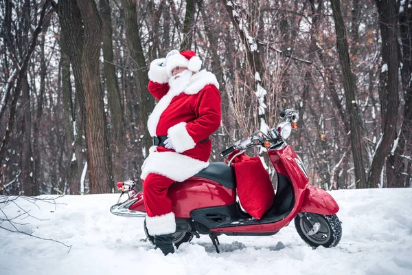 Santa Claus zittend op de rode scooter — Stockfoto