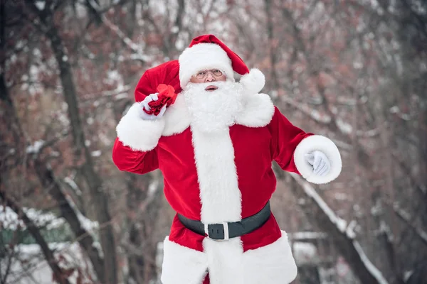 Santa Claus wandelen met zak vol cadeaus — Stockfoto