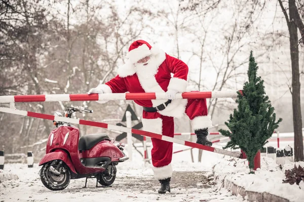 Santa Claus klättra över hinder — Stockfoto