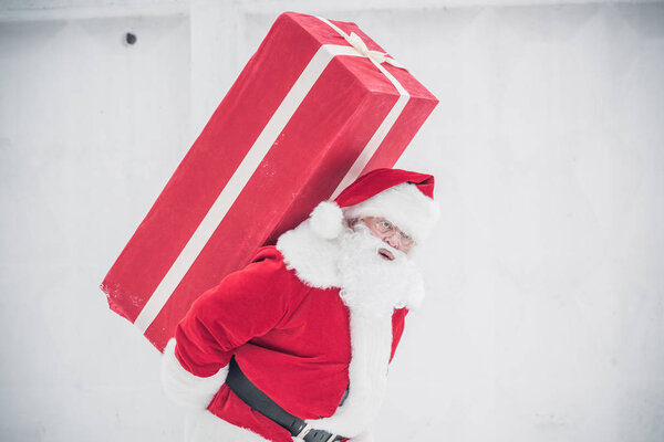 Santa Claus carrying gift box 