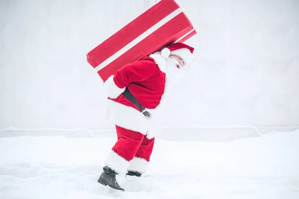 Weihnachtsmann trägt Geschenkbox — Stockfoto