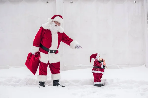 Weihnachtsmann zeigt auf Weihnachtsspielzeug — Stockfoto