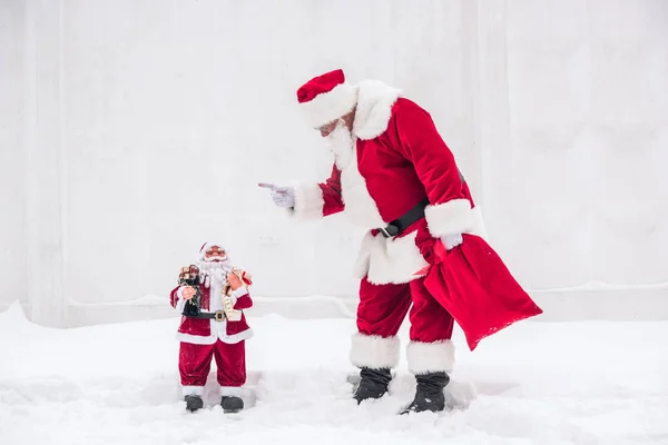 Papá Noel regañando al pequeño Papá Noel — Foto de stock gratis