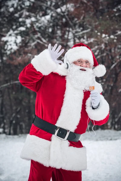 Santa Claus listening to music in headphones — Stock Photo, Image