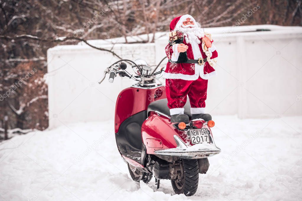 Santa Claus standing on back of scooter