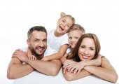 Usmívající se rodina v bílých tričkách objímání 