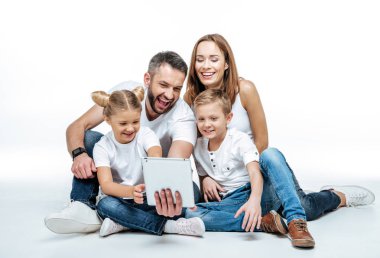 Gülümseyen aile dijital tablet kullanma