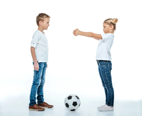 Frères et sœurs debout avec un ballon de football — Photo