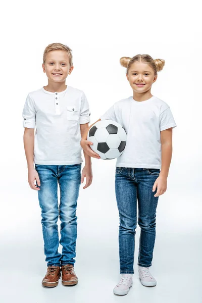 Usměvavé děti stojící s fotbalovým míčem — Stock fotografie