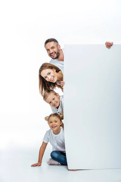 Familia sonriente sosteniendo tarjeta en blanco — Foto de Stock