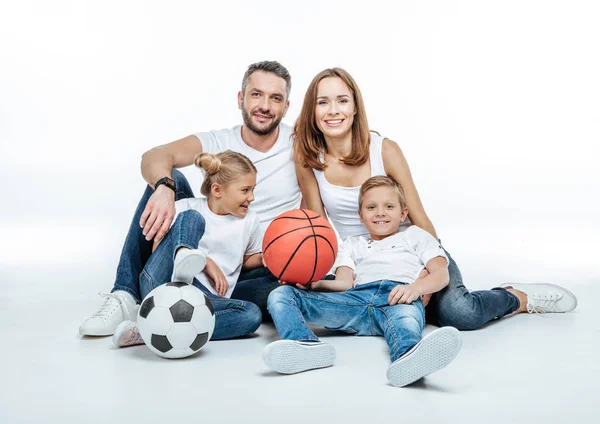 Весела сім'я з футбольними та баскетбольними м'ячами — стокове фото