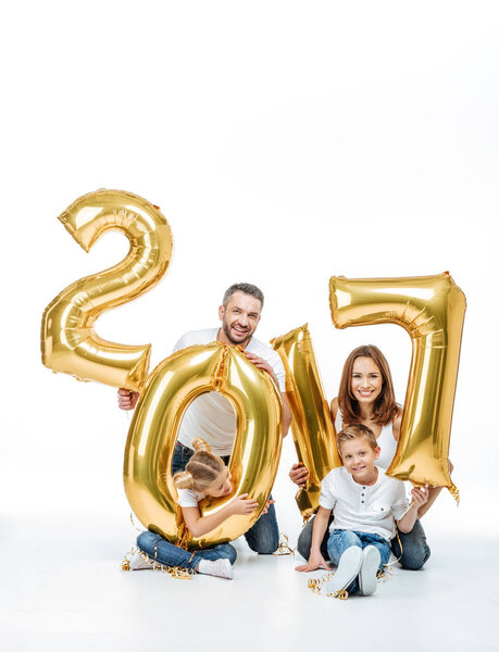 Happy family holding golden balloons 