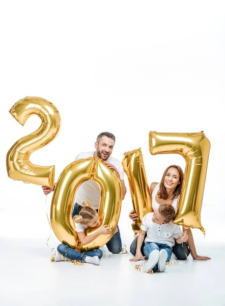 Happy family holding golden balloons — Stock Photo, Image