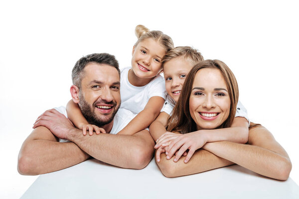 Smiling family in white t-shirts hugging 
