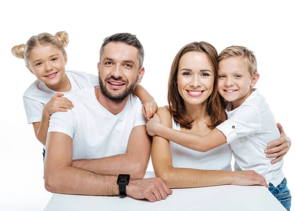 Familia sonriente en camisetas blancas abrazándose — Foto de Stock