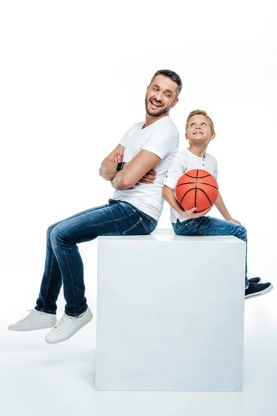 Father and son sitting with basketball ball — Stock Photo, Image