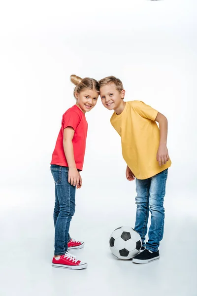 Siblings standing with soccer ball — Stock Photo, Image