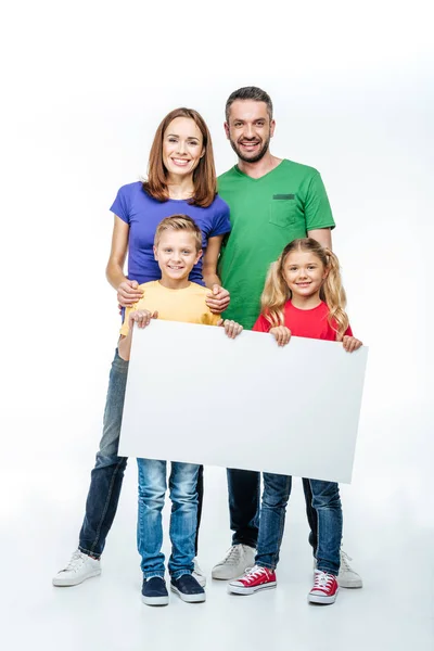 Família de pé com cartão branco em branco — Fotografia de Stock