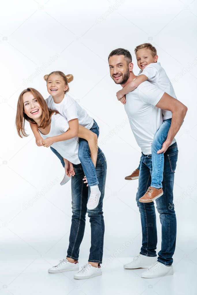 Parents piggybacking happy children