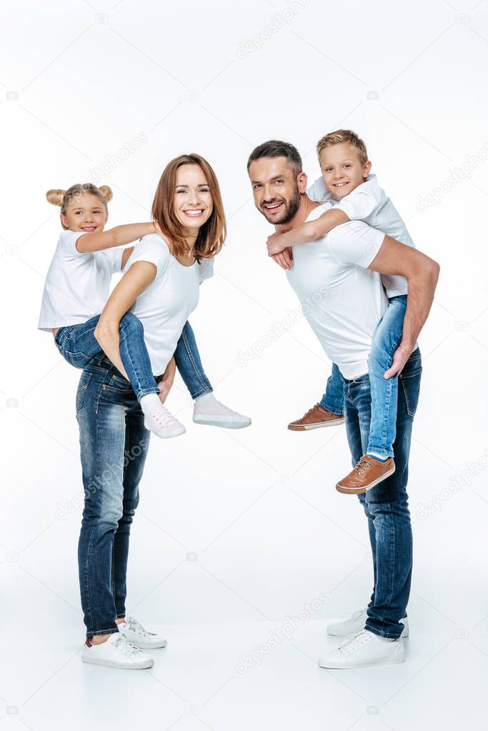 Parents piggybacking happy children