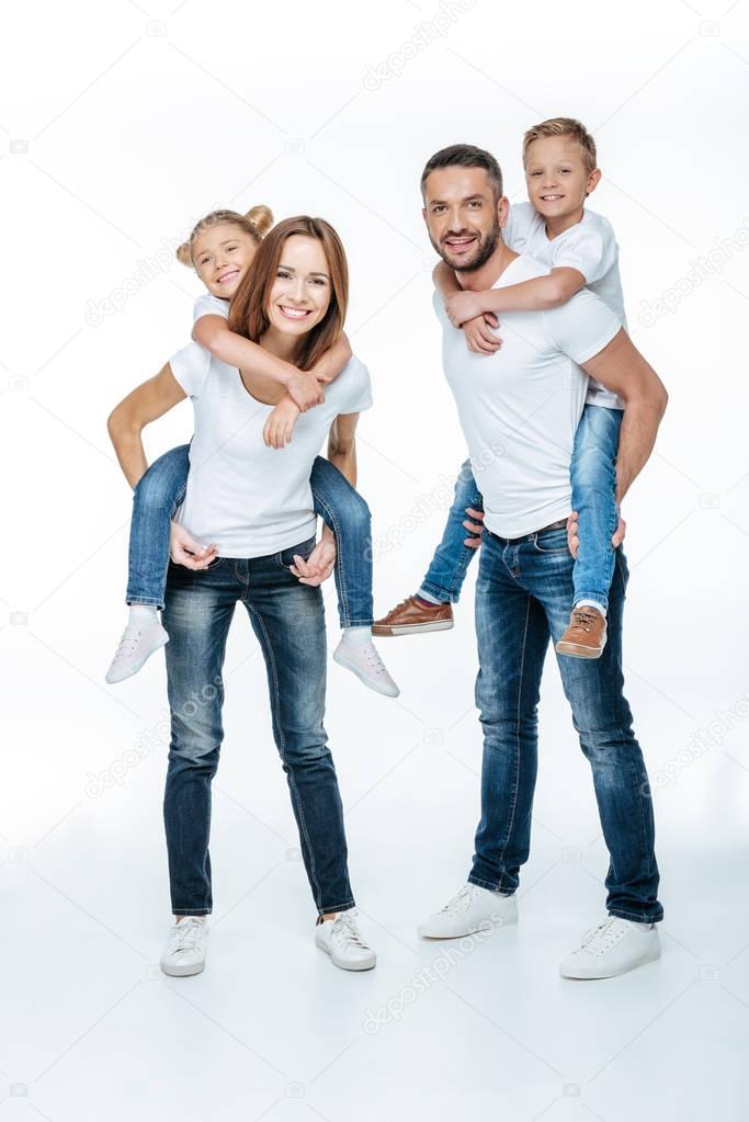 Parents piggybacking happy children