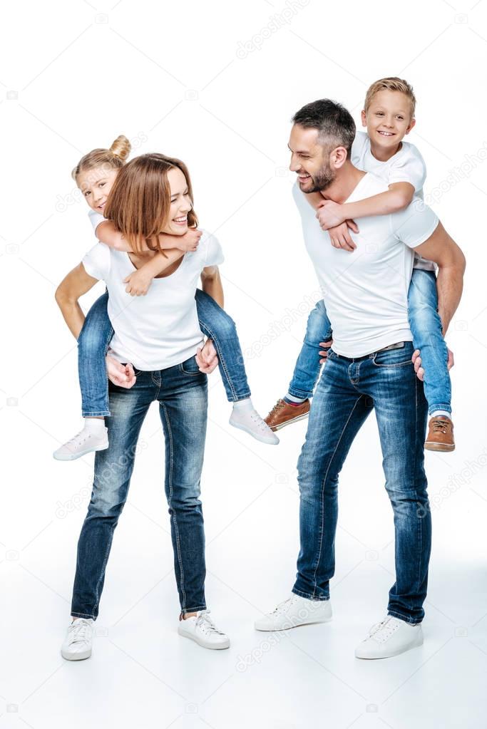 Parents piggybacking happy children