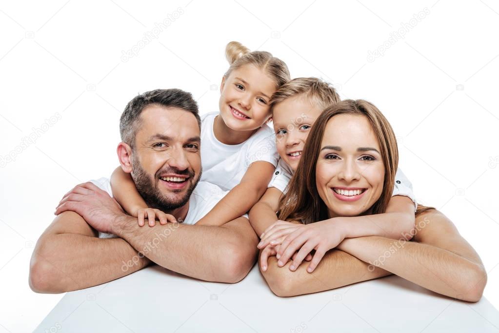 Smiling family in white t-shirts hugging 