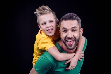 Smiling father piggybacking son clipart