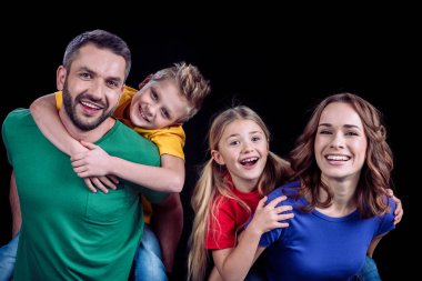 kameraya gülümseyen mutlu bir aile