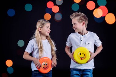 Smiling siblings holding frisbee  clipart