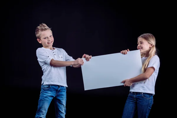 Sorridenti fratelli con carta bianca — Foto Stock