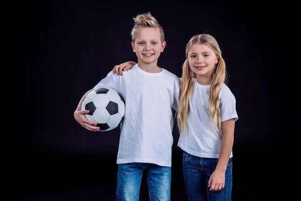 Irmão e irmã posando com bola de futebol — Fotografia de Stock