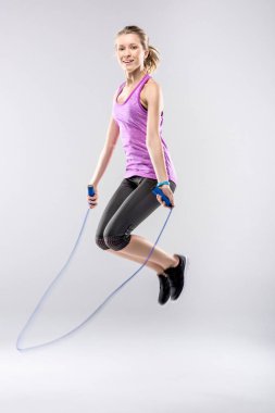 Woman exercising with skipping rope  clipart
