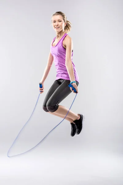 Mujer haciendo ejercicio con saltar la cuerda — Foto de Stock