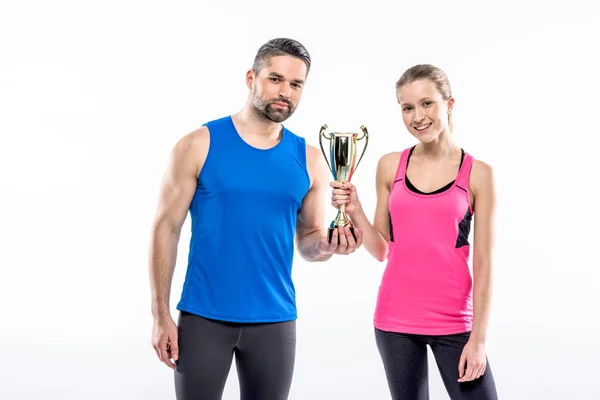 Sportive couple with award cup — Stock Photo, Image