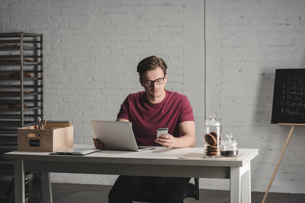 Серьезный человек с помощью смартфона