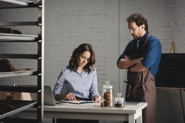 Bakers discussing and making notes — Stock Photo, Image