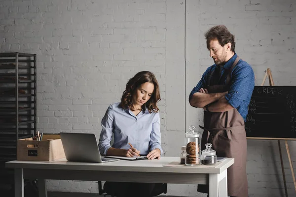 Bakers discussing and making notes — Stock Photo, Image