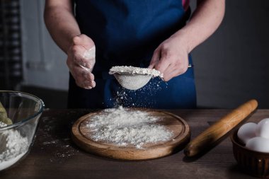 Baker sifting flour  clipart