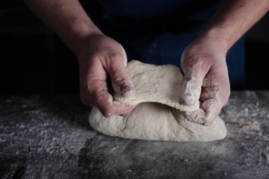 Baker examining dough