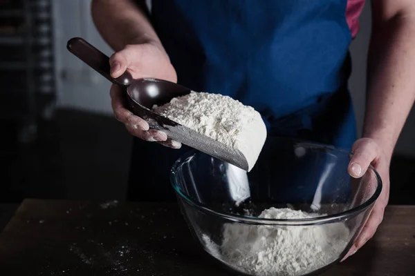 Baker peneirando farinha — Fotografia de Stock